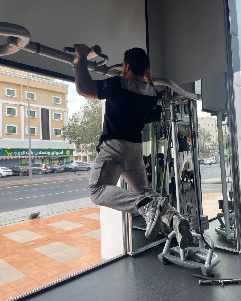 متدرب على جهاز سحب قرب واجهة My Gym الزجاجية